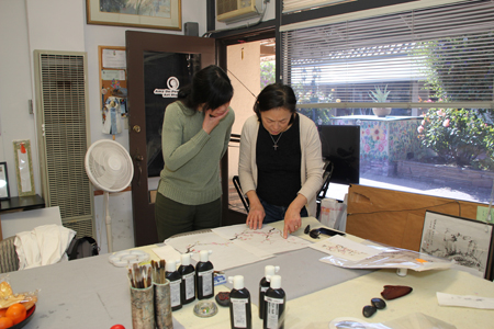 Amy and a student reviewing assessing progress on traditional cherry blossom technique